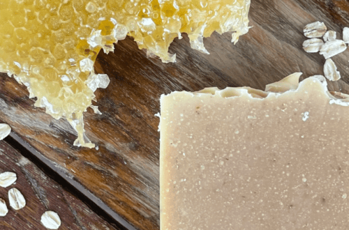 natural ingredients, oats and honey soap with a honeycomb and oats on a wood table