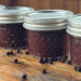 elderberry juice canned next to fresh elderberries on the table