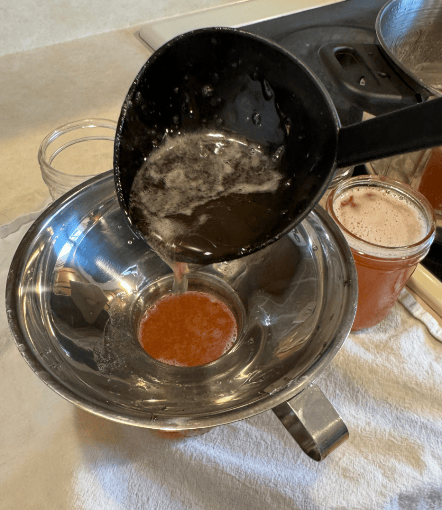 ladling low sugar rhubarb jelly into jars