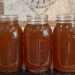 Three quart jars of homemade beef bone broth cooling on the stove