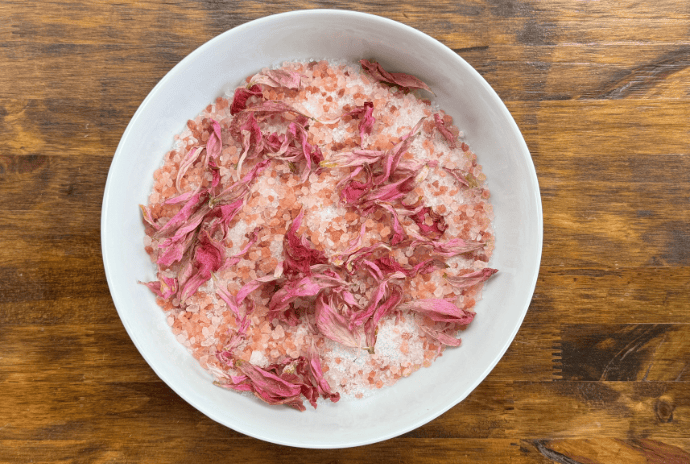Peony bath soak ingredients mixed together in a white bowl