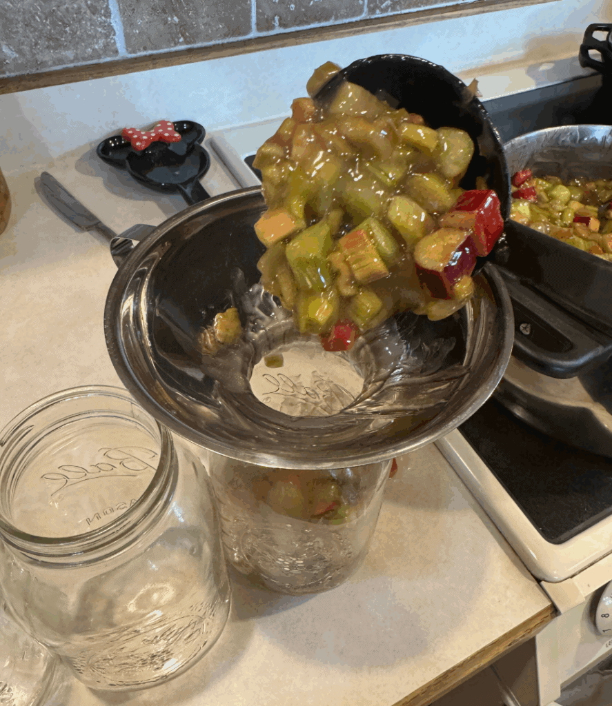 ladling hot rhubarb pie filling to jars