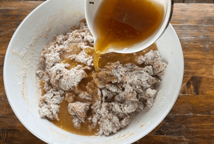 apple cider being poured into donut bread batter