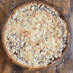 black raspberry pie with crumble top in a glass pie dish