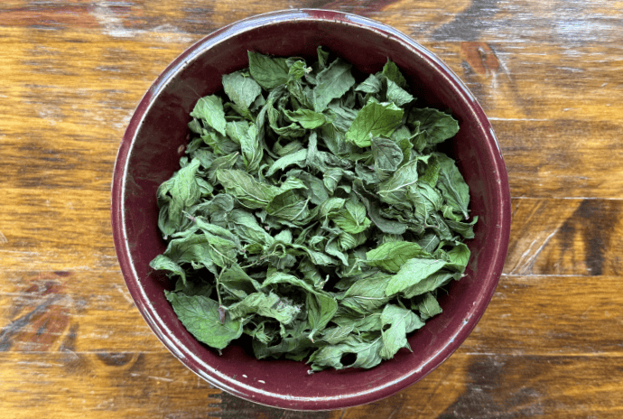 dried peppermint leaves in a maroon bowl