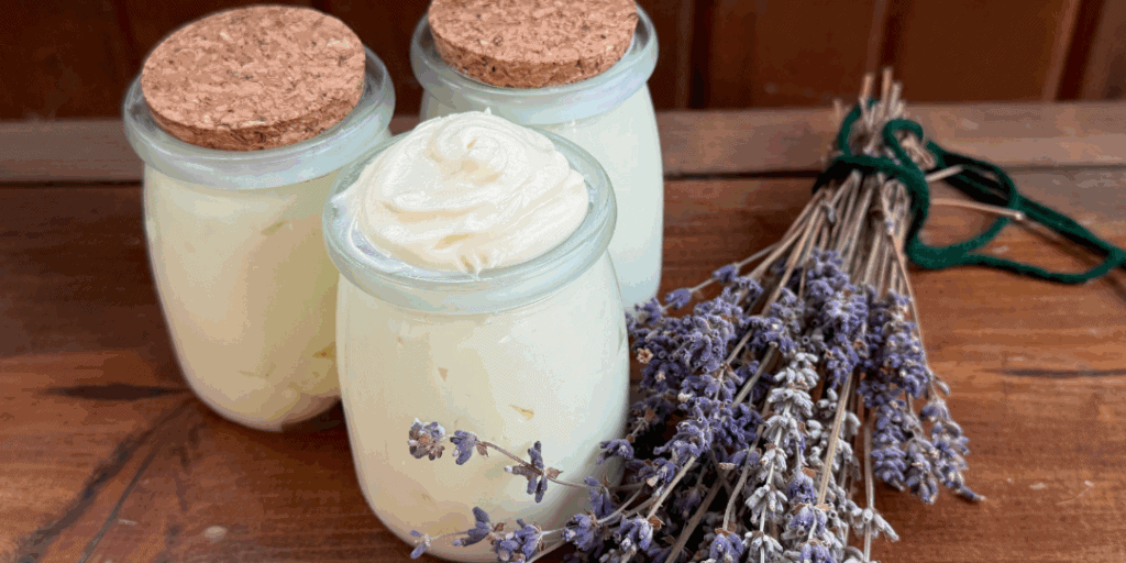 Three tallow balms in tins next to dried lavender for soothing natural skincare