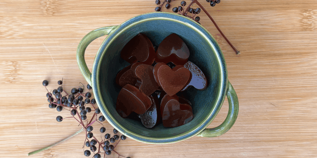 heart shaped elderberry gummies with elderberries on the step in a bowl