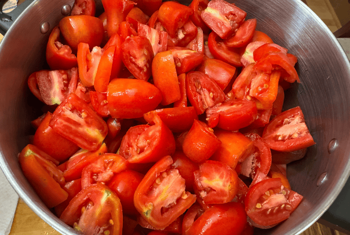 cut tomatoes ready to be cooked and canned