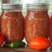 homemade canned salsa with garden fresh tomatoes and jalapenos on the table