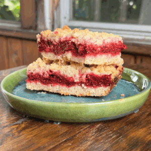 homemade thimbleberry crumble with golden brown crumble topping cut into bars