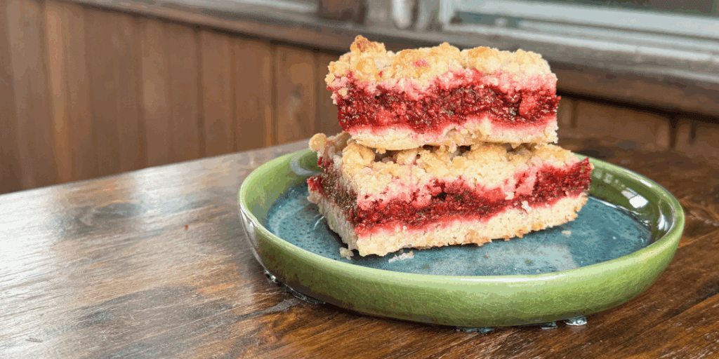 homemade thimbleberry crumble cut into bars on a plate