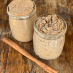 pumpkin spice sugar scrub in yogurt containers with a cinnamon stick.
