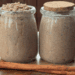 pumpkin spice tallow sugar scrub in jars with a cinnamon stick