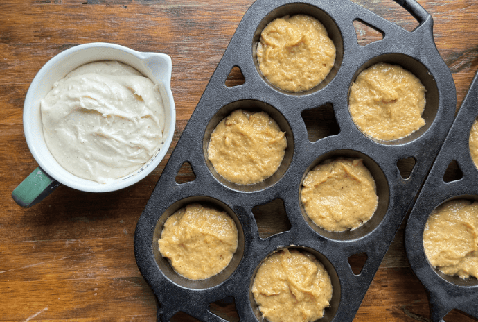 uncooked pumpkin muffin batter in pan with filling in a bowl