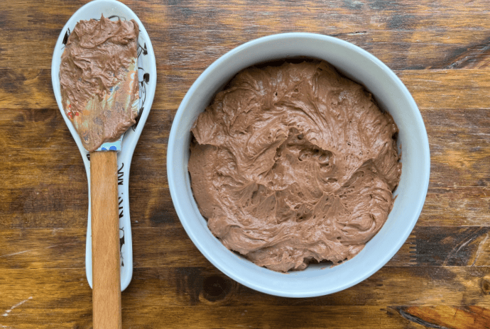 homemade whipped chocolate buttercream frosting in a white bowl