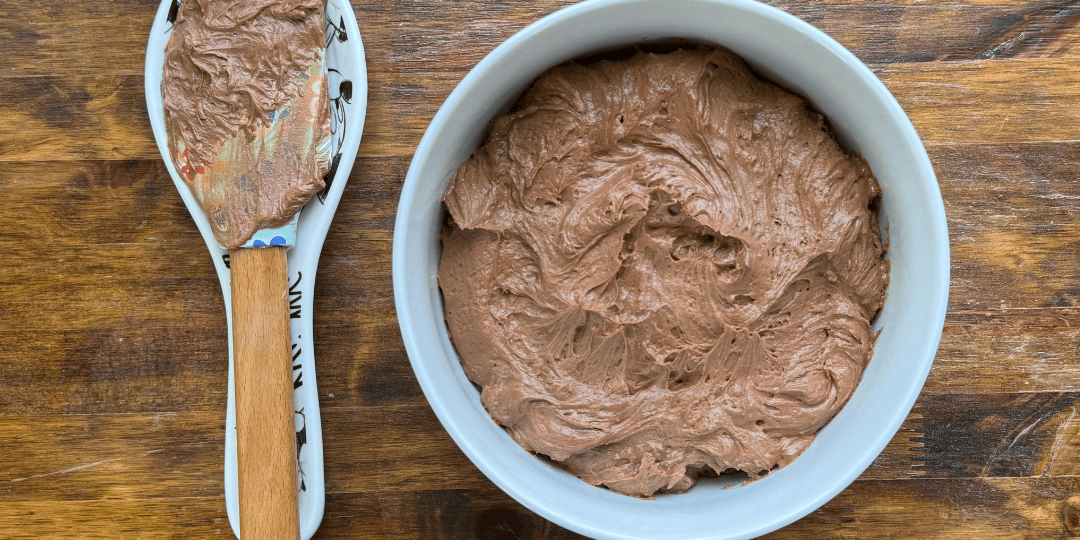 homemade whipped chocolate frosting in a white bowl