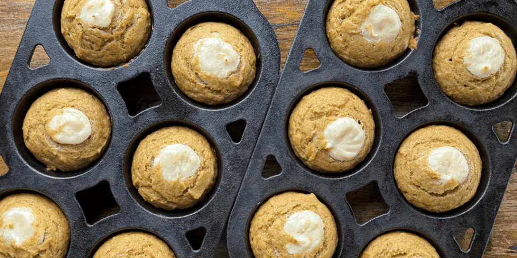 baked pumpkin cream cheese muffins in cast iron muffin pans